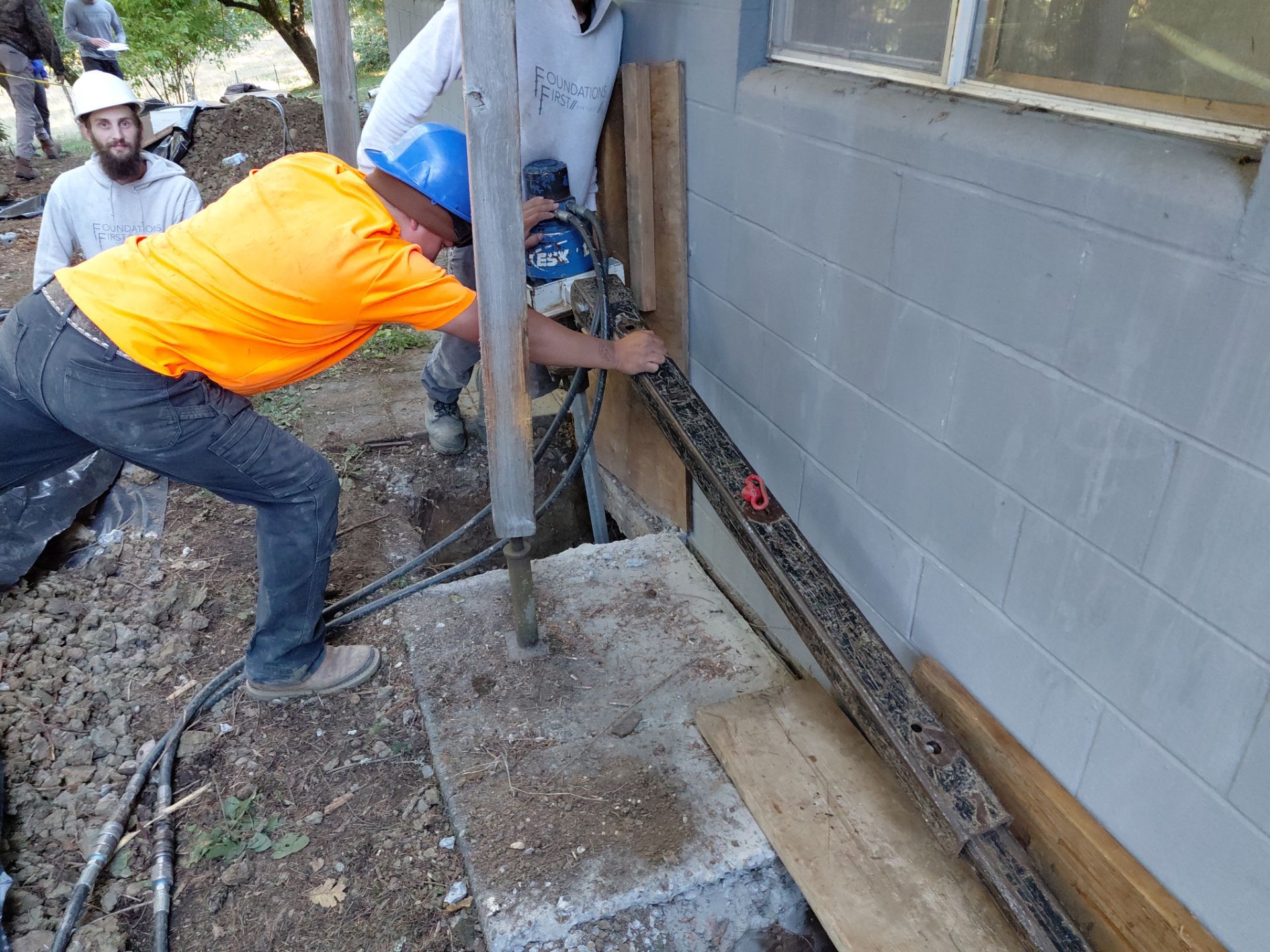 construction crew using to perform helical pile installation on a residential building, Texas