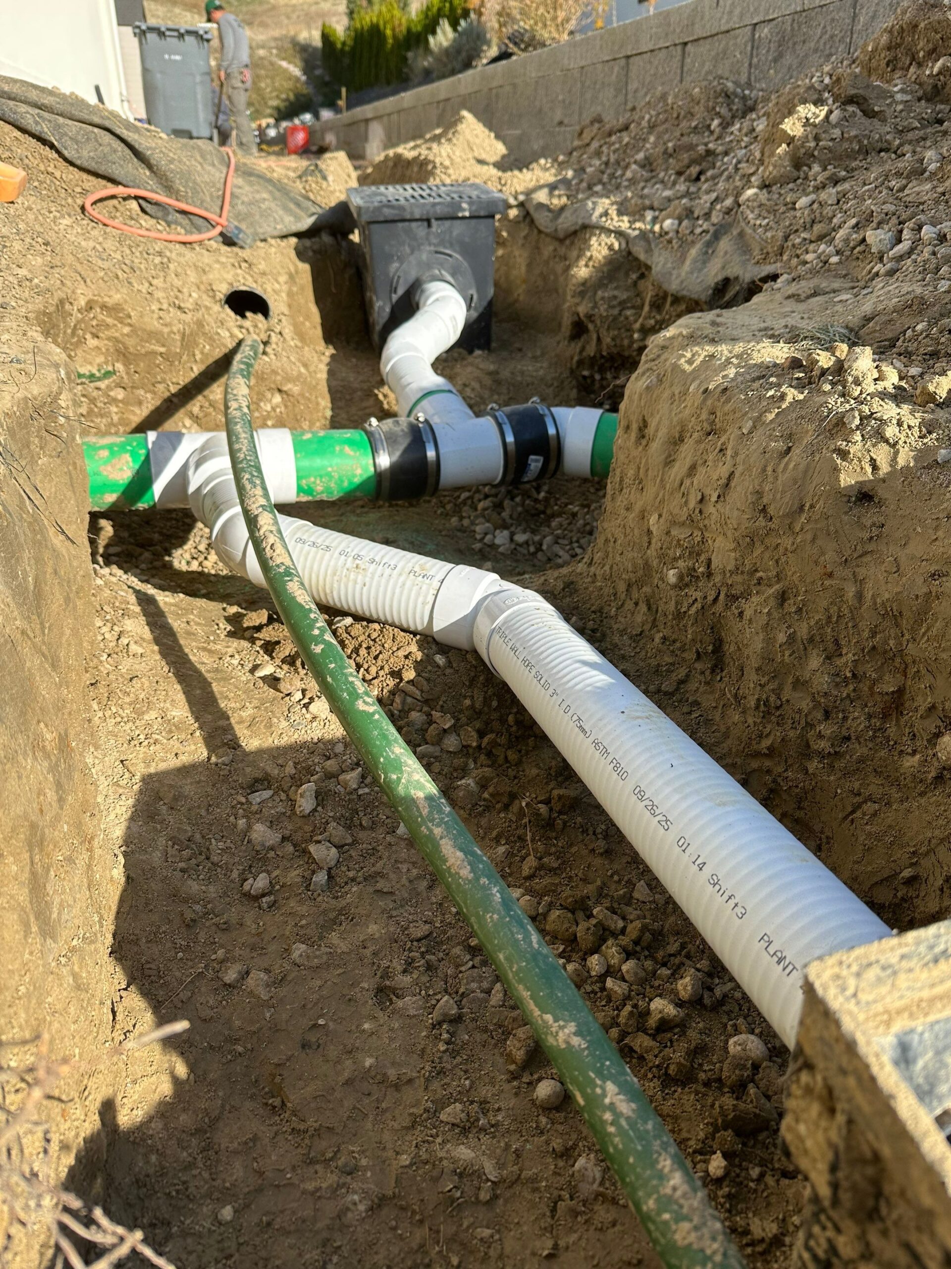 French drain with water Stones near House Wall